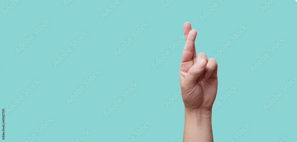 Wall mural hand with crossed fingers on blue background - luck concept