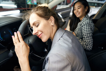 Happy woman lean face on steering wheel