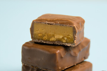 Delicious chocolate bars with salted caramel on a blue paper background