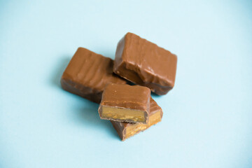 Delicious chocolate bars with salted caramel on a blue paper background