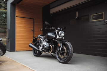 Obraz premium Modern garage doors with carport motorcycle parked in the driveway. Motorcycle in front of house. Generative AI
