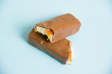Tasty chocolate bar with white nougat and caramel on a blue background