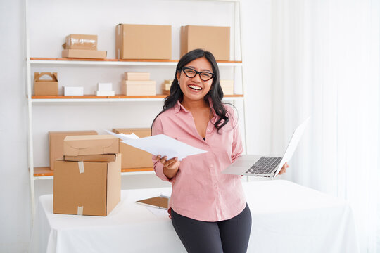 Photo of smiling Asian business woman, successful entrepreneur, elegant professional company executive ceo manager standing in office holding laptop