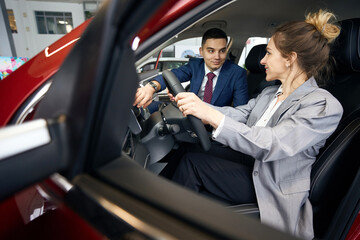 Man and woman in suits sitting in car
