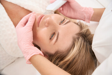Obraz na płótnie Canvas Woman on wellness ultrasonic facial cleansing procedure