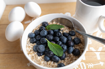 Soaked oats in water with fresh blueberries in a bowl for breakfast