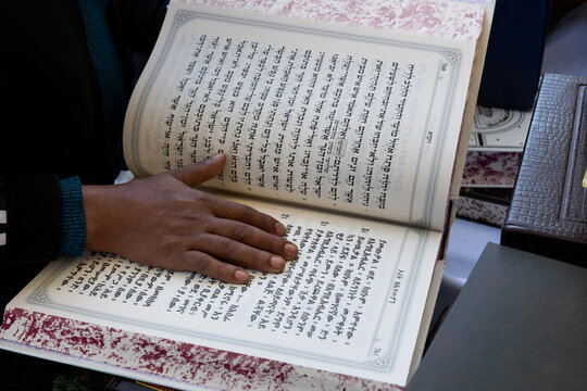 Jewish Ethiopian man reading from the Jewish bible or Torah in Amharic.