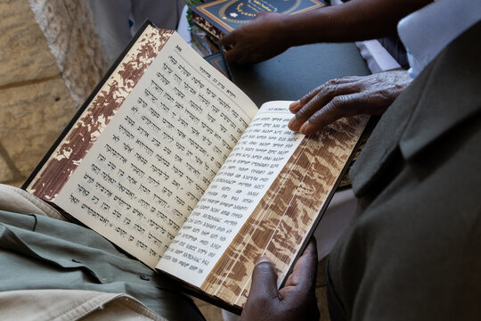 Jewish Ethiopian man reading from the Jewish bible or Torah in Amharic