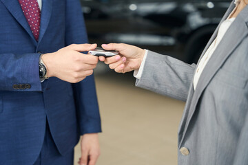 Business people in suits holding car key in hands