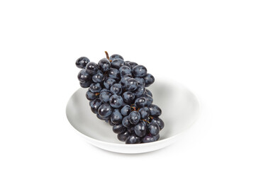 Branch of ripe blue grape on plate isolated white background. Juicy grapes with copy space