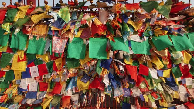 Small colored flags with buddhist symbols and mantras are tied to the fence of the temple