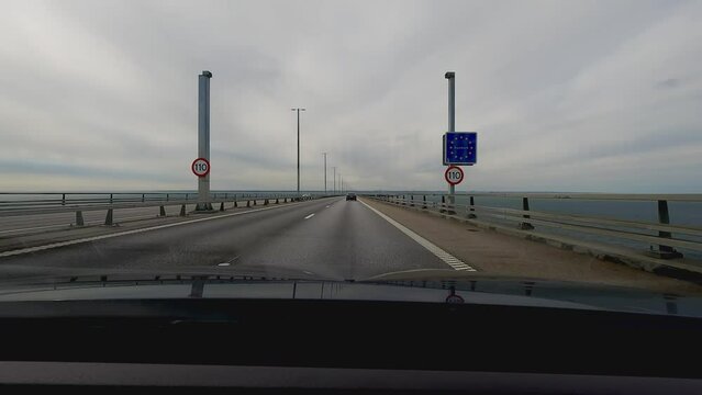 Crossing the border into Denmark from Sweden. Driving on the Oresund Bridge connecting Copenhagen and Malmo. Point of view.