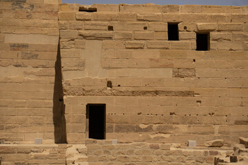 Muro di un tempio egizio, con blocchi di mattoni ben delineati e tre aperture di cui una porta e...