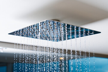 Water flows from the tropical shower. Large water consumption. Chrome large shower head, modern...