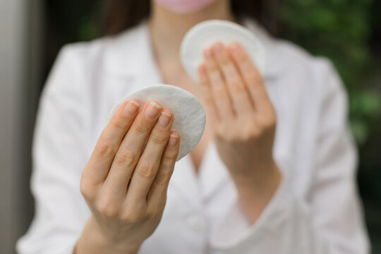 Image of hands holding cotton pads. Skin care concept. Mixed media