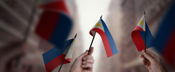 A group of people holding small flags of the Philippines in their hands