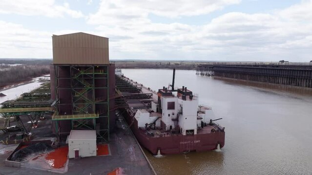 Freight shipping vessel de-ballasting water during exportation of iron taconite at ore dock in Wisconsin