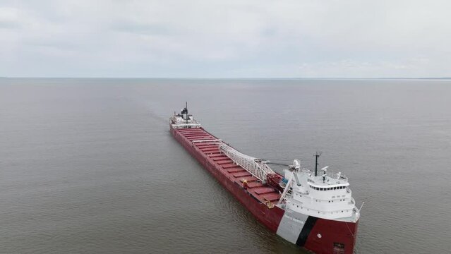 Large natural resources freight shipping vessel transporting minerals along commercial trade route