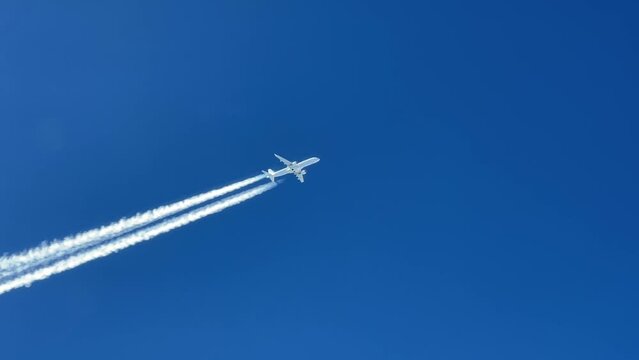 White jet airplane shot from another jet cabin flying parallel track 2 levels bellow