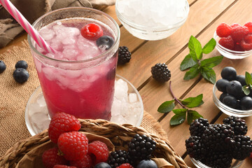 Cold fruit beverage with berries with fruit and ice elevated