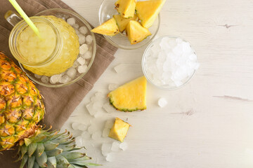 Background with pineapple drink with ice on table top view