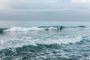 Background image of turquoise sea waves on a sunny day.