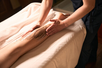 Professional massotherapist giving anti-cellulite massage to patient