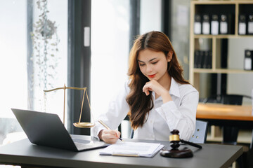 Beautiful asian woman lawyer working and gavel, tablet, laptop in front, Advice justice and law concept.