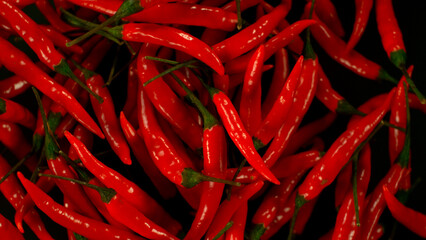 Chilli peppers flying up in the air. Freeze motion. Isolated on black background.