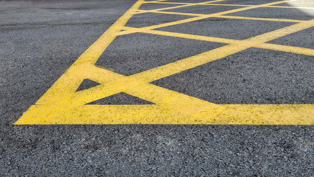 Yellow line. Band of yellow reflective paint on a black asphalt. Yellow line on road texture. Road marking. High quality photo