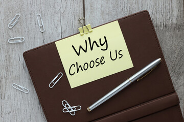 Question Why choose us on notebook closeup. on a light wooden background