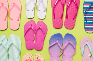 Many colorful flip flops on color background, top view