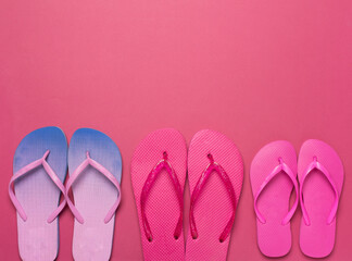 Many colorful flip flops on color background, top view