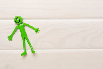 Human figure toy on wooden background, top view