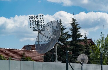 siatkowa antena satelitarna zamontowana na dachu budynku.