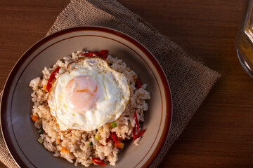 Fried rice with fried egg on top. indo-china food with green onion, carrot and red chili - obrazy, fototapety, plakaty