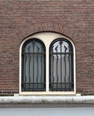 Fototapeta na wymiar Amsterdam Nes Street Arched Window with Window Grill Close Up, Netherlands