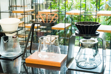Coffee brewing gadgets on wooden bar counter in coffee shop.