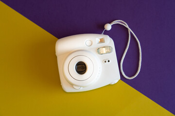 Traditional plastic photo camera on a colored background. View from above. Icon