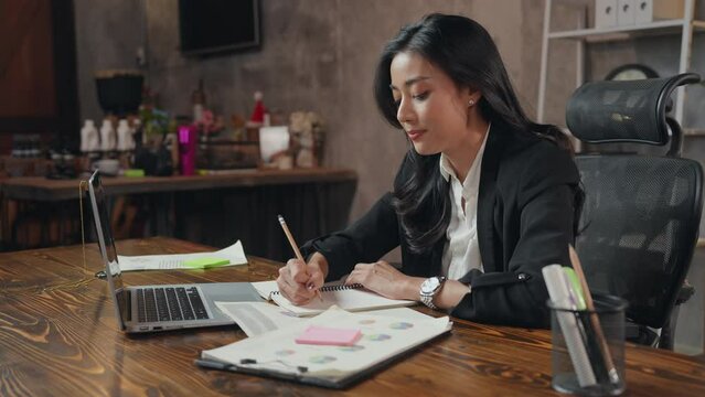 A business woman is using Video call on laptop to make an online conference. A beautiful confidence female employee is talking presenting, consulting, interviewing or meeting and briefing company work