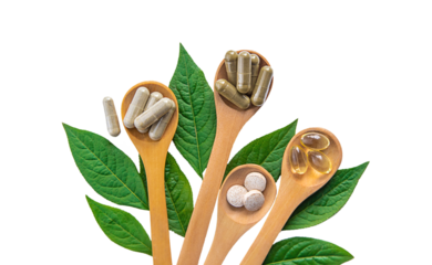 Herb supplement capsules on green leaf isolate on white background. Selective focus.