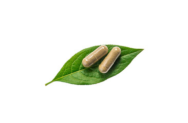 Herb supplement capsules on green leaf isolate on white background. Selective focus.