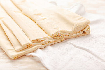 Raw phyllo pastry, thin filo dough for baking, for pie and cakes on wooden kitche table