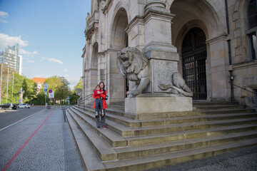 children near the sculpture of a lion at the base of the steps to The New Town Hall (Neues Rathaus) is a city hall in Hanover
