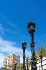 Fototapeta na wymiar Street lamps on promenade in front of La Caleta beach in Cadiz, Spain on April 30, 2023 