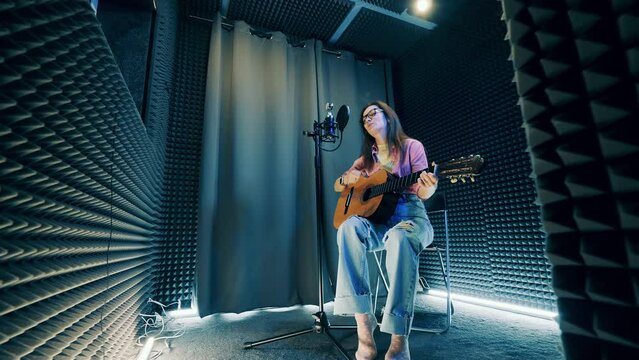 Young woman singing in the professional music studio, sound recording concept.