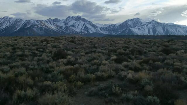 Aerial Cinematic drone Mammoth Lakes California Sierra Nevada  hilltop hot spring field and mountain landscape late after sunset up to the forward pan up reveal movement
