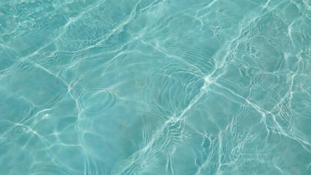 Water drop in swimming pool. Blue color. Ocean lockdown surface. Stop motion video. H2O hotel relax. Sea wave summer texture. Crystal wet waves. Float calm splash. Nobody liquid background