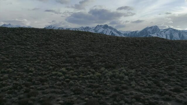 Aerial Cinematic drone Mammoth Lakes California Sierra Nevada  hilltop hot spring field and mountain landscape late after sunset up movement reveal