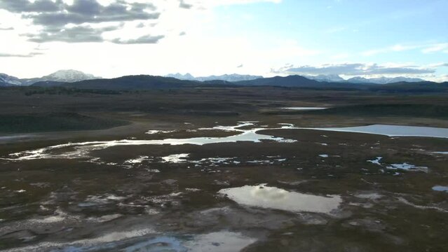 Aerial Cinematic drone Mammoth Lakes California Sierra Nevada  hilltop hot spring field and mountain landscape late after sunset up skier snowboarders soak camp to the forward right movement